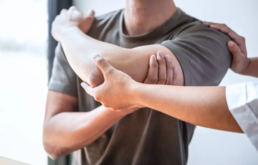 Kiropraktor utför behandling av tennisarmbåge och golfarm för att minska smärta och förbättra funktion